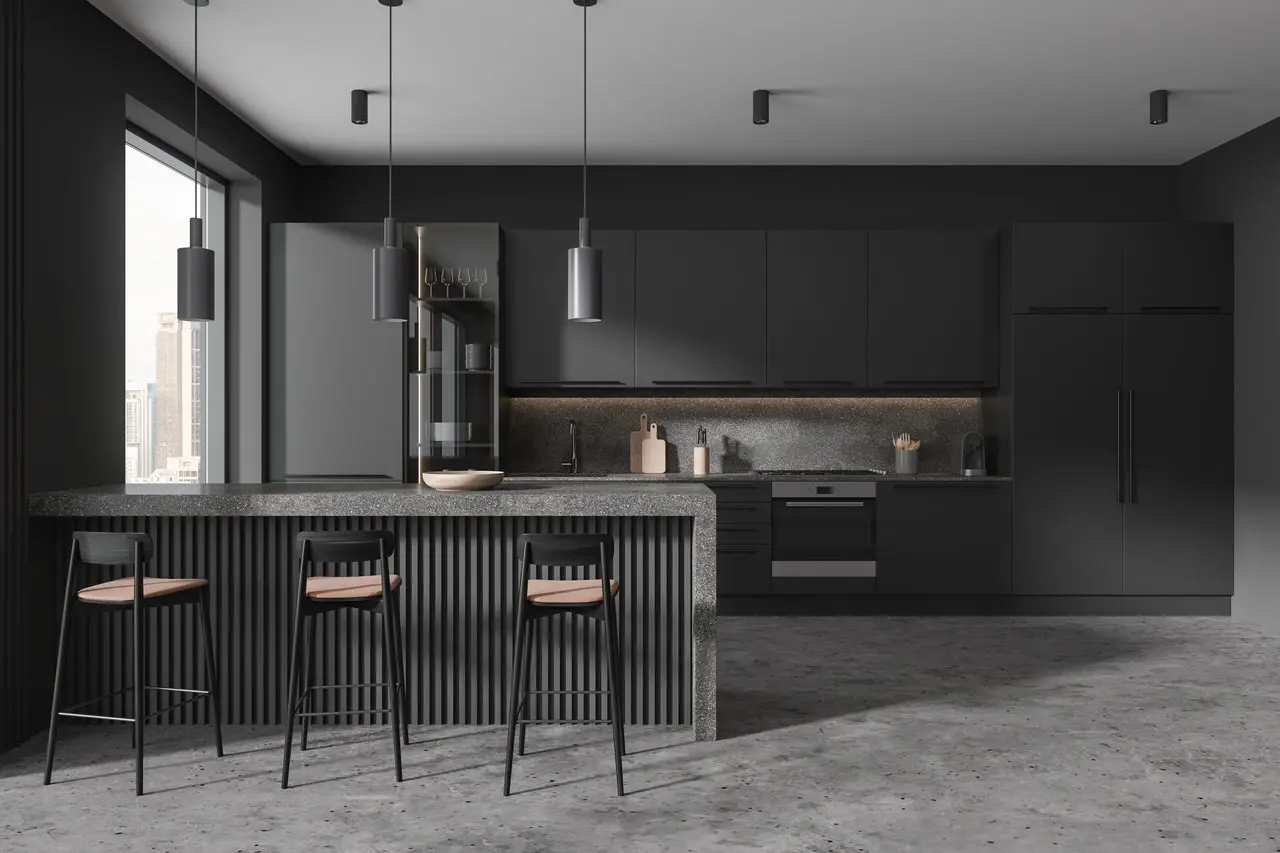 Modern kitchen with dark cabinetry, a large island with stools, pendant lighting, and built-in appliances. A window allows natural light to enter, illuminating the space.