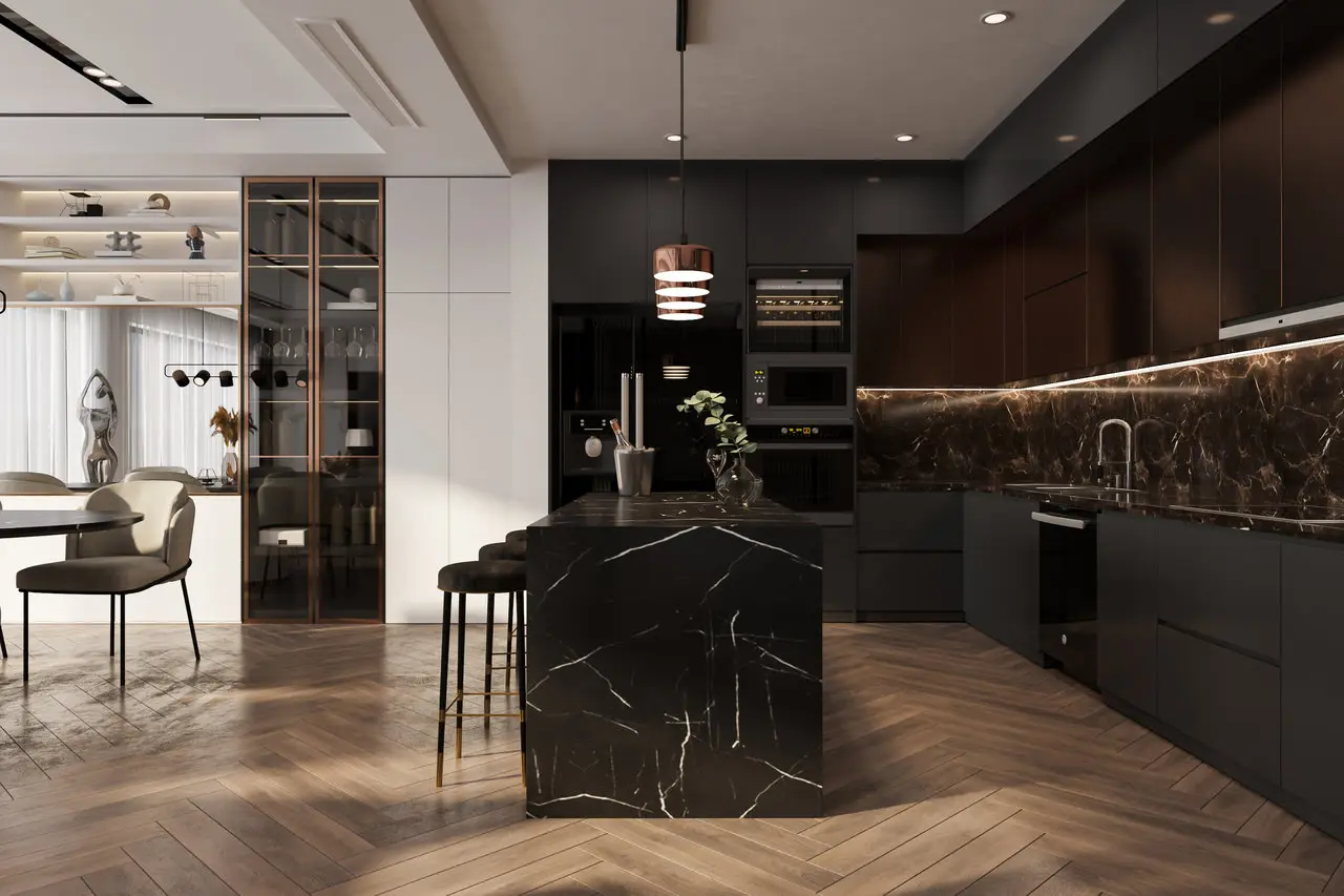 Modern kitchen interior with dark cabinets, a marble island, and wooden herringbone flooring. Dining table with chairs in the background and decorative shelves on the left.