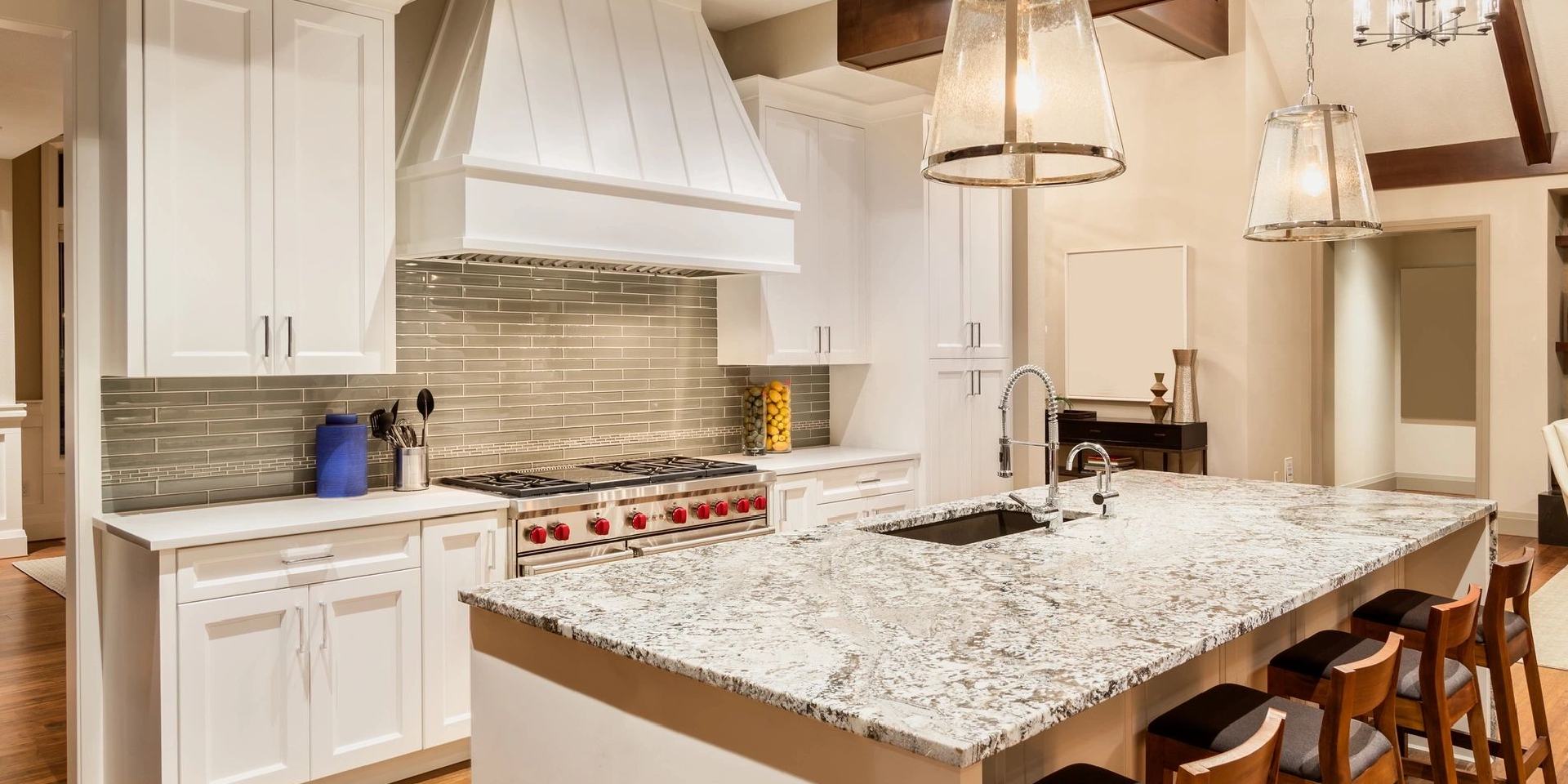 A kitchen with white cabinets and granite counter tops.