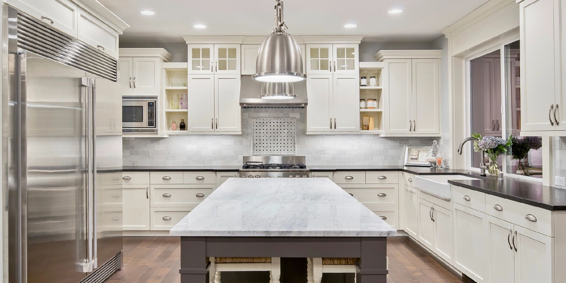 A kitchen with white cabinets and a large island.