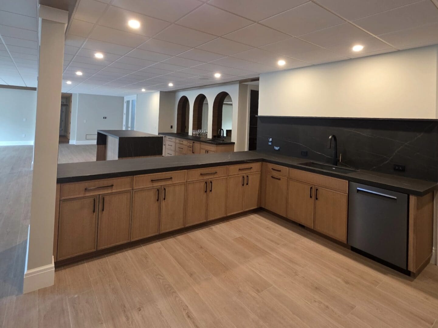 Modern basement wet bar with wooden cabinets