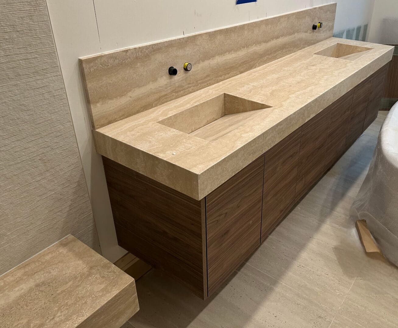 Floating wooden vanity with double travertine sinks