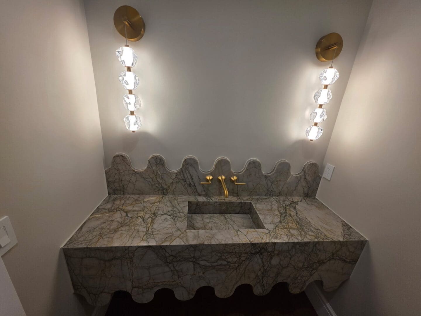 Scalloped marble vanity with brass faucet