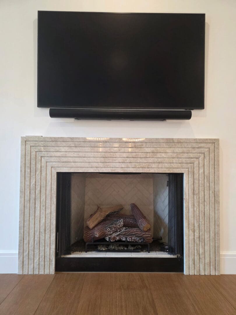 Flat-screen TV and soundbar above stone fireplace