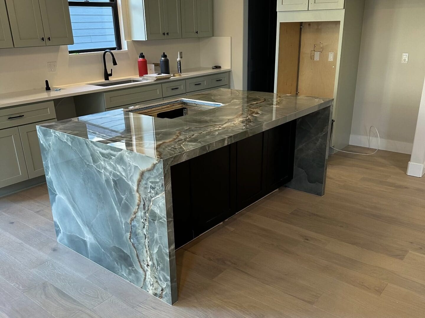 Glossy waterfall stone kitchen island in progress
