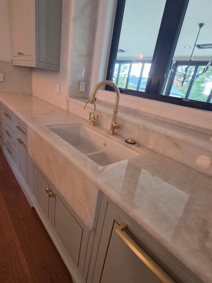 Marble countertop apron-front sink with brass faucet