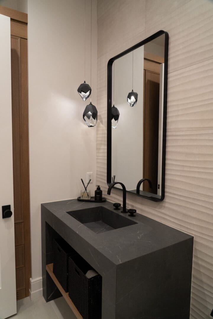 Modern dark stone vanity with pendant lights