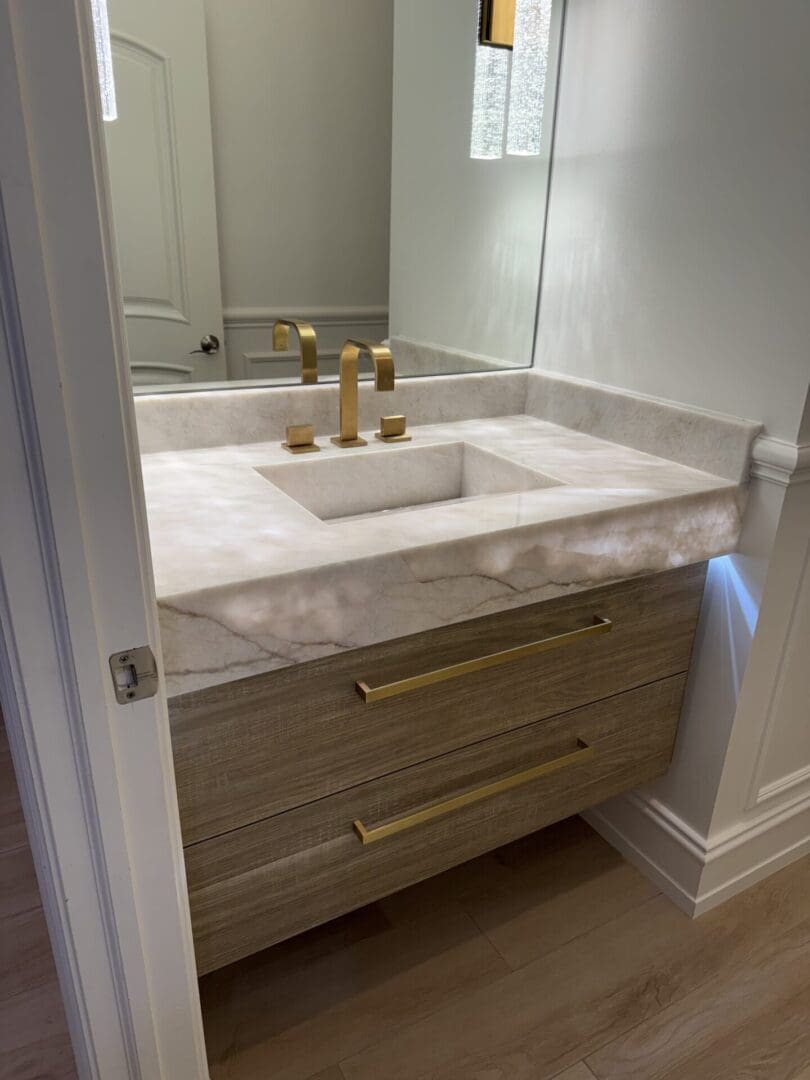 Marble vanity with integrated sink and brass fixtures
